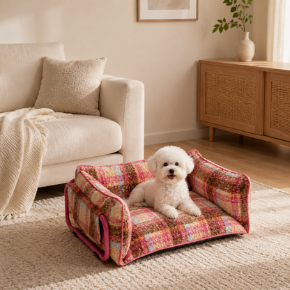 Small white dog relaxing in a plaid plush sofa dog bed