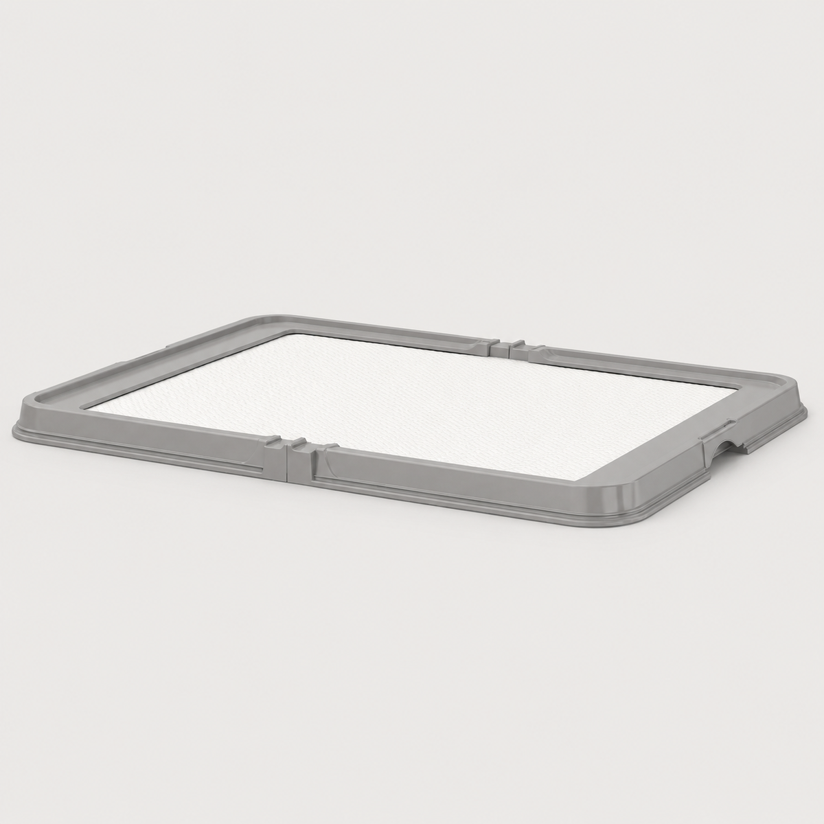 Gray foldable dog pee pad tray with white absorbent training pad on a neutral background