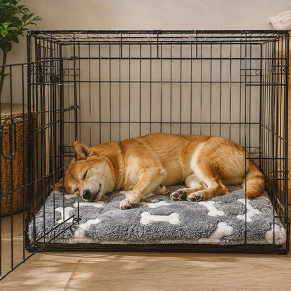 Dog sleeping comfortably on a self-warming mat inside a crate
